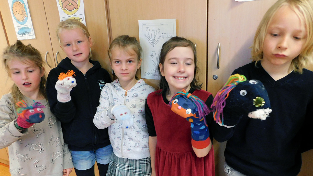 Kinder der zweiten Klassen als Puppenspieler